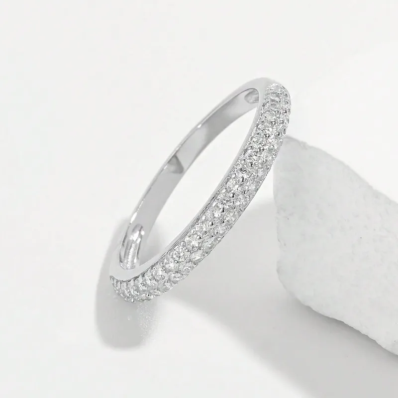 Silver ring with small diamonds on a white surface